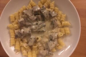 Ein Tellergericht mit Nudeln und Steakwürfeln in Parmesansauce