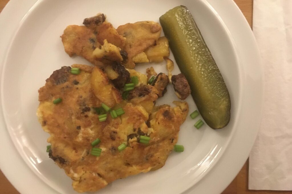 Bauernfrühstück mit Frühlingszwiebeln und Beilagegurke.