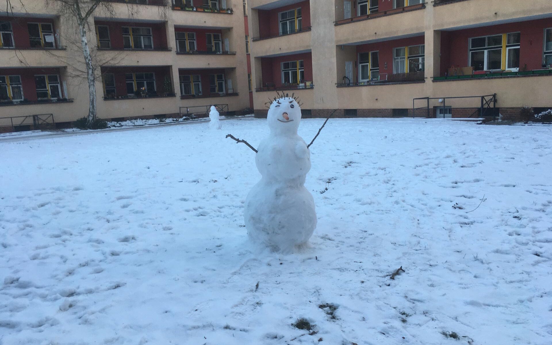 Ein Schneemann auf verschneitem Rasen.