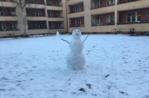 Ein Schneemann auf verschneitem Rasen.