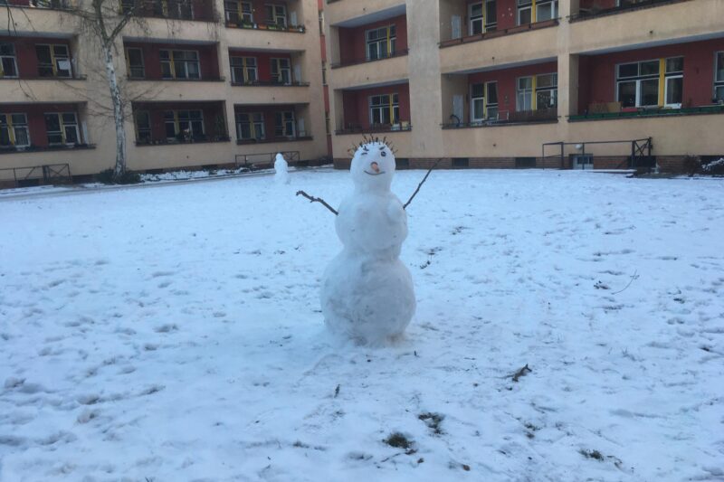 Ein Schneemann auf verschneitem Rasen.