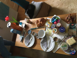 Ein Frühstückstisch an Ostern, mit bunten Eiern und Hefezopf.